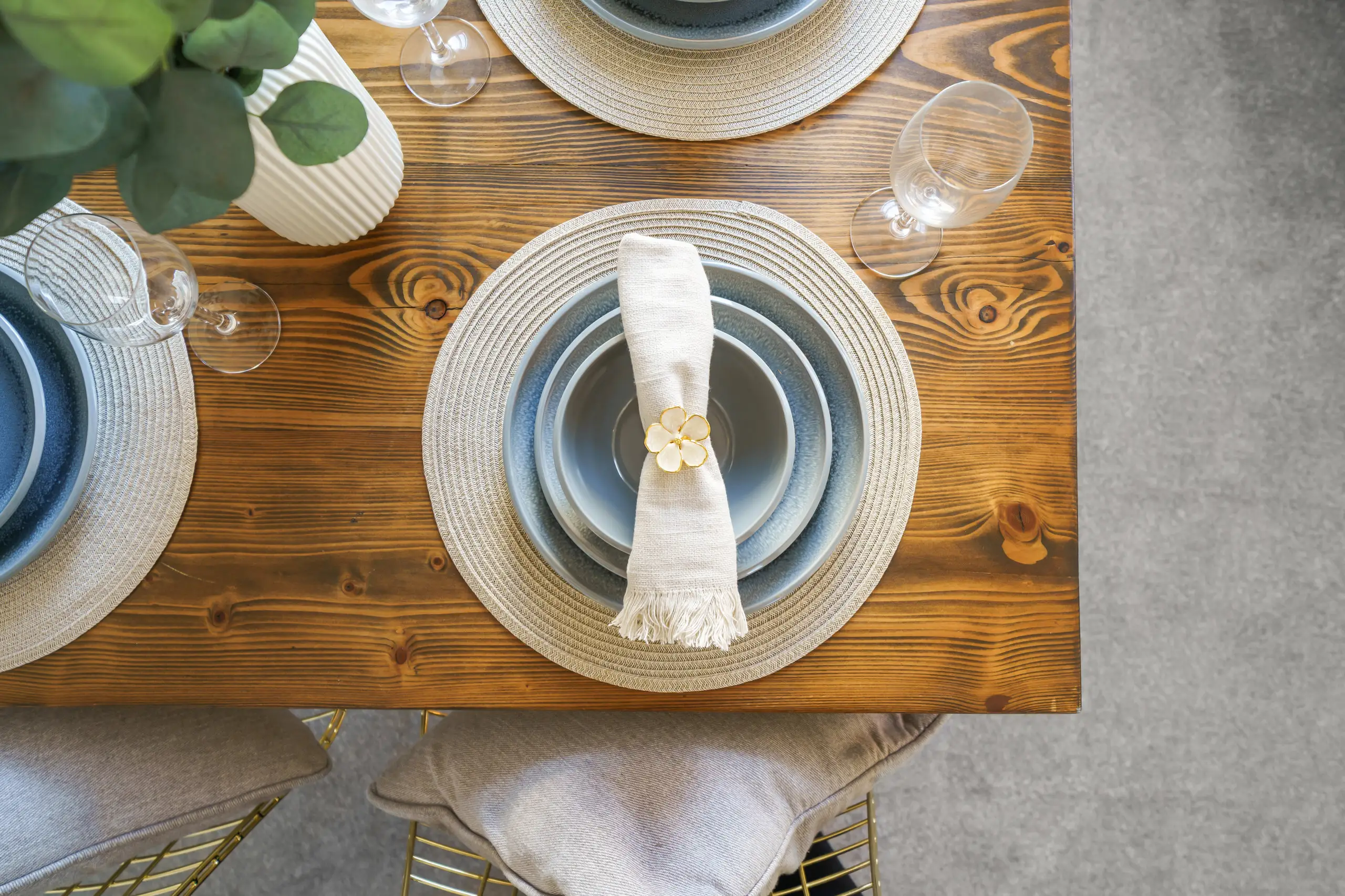 Overhead view of a place setting with a linen napkin on a timber dining table