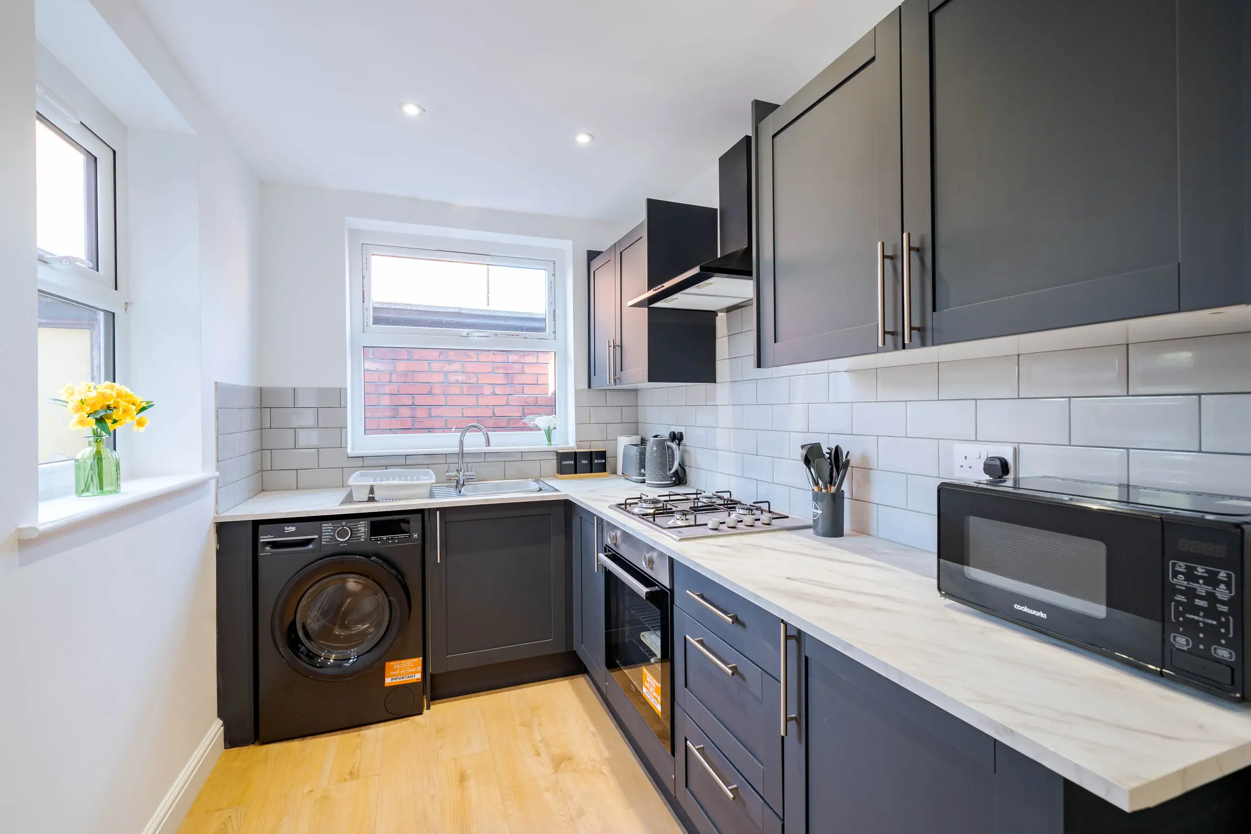 Charcoal shaker-style kitchen with white metro tiles and marble-effect worktops